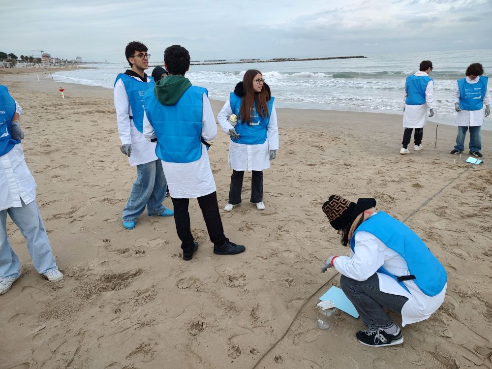 Campionamento della sabbia con gli Studenti del Montani per le future analisi green sulle microplastiche. L'immagine ritrae gli Studenti del Montani durante il campionamento della sabbia per le future analisi green sulle microplastiche.